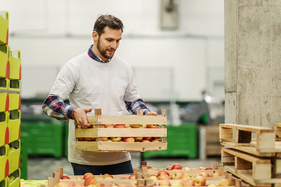 Man holding crate of fruit